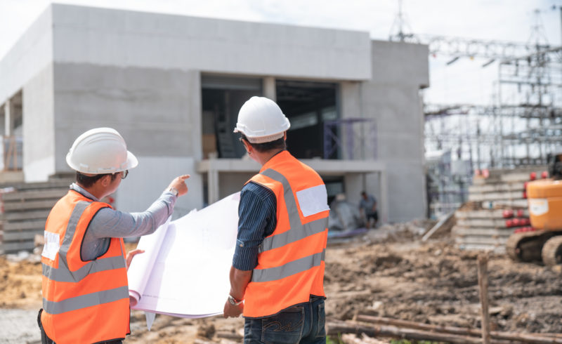 Construction engineers discussion with architects at construction site