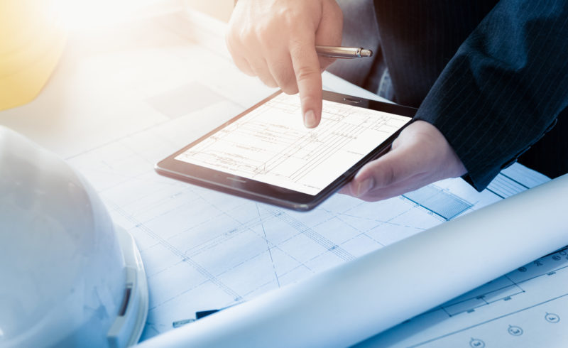 Businessman or engineering holding and using a tablet in the morning at office